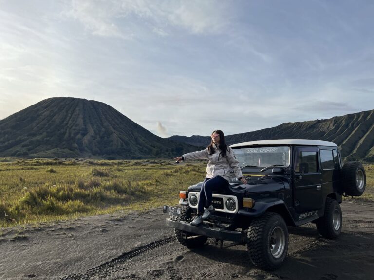 Black 4x4 jeep on the Sea of Sand with Mount Batok behind