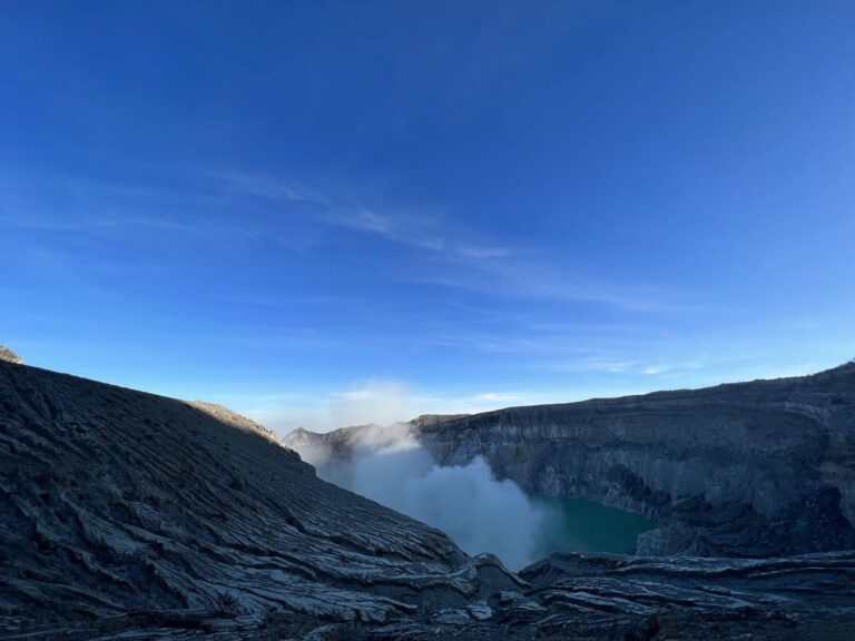 Kawah Ijen crater rim and lake with sulfur smoke
