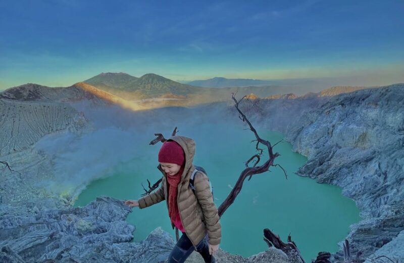 A hiker on the Ijen crater rim in the blue light of dawn