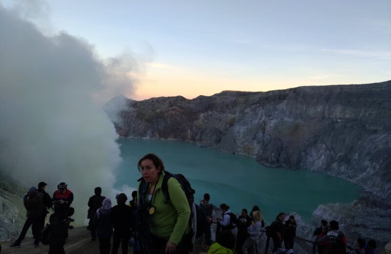 Hikers gathered at the Ijen crater rim at dawn