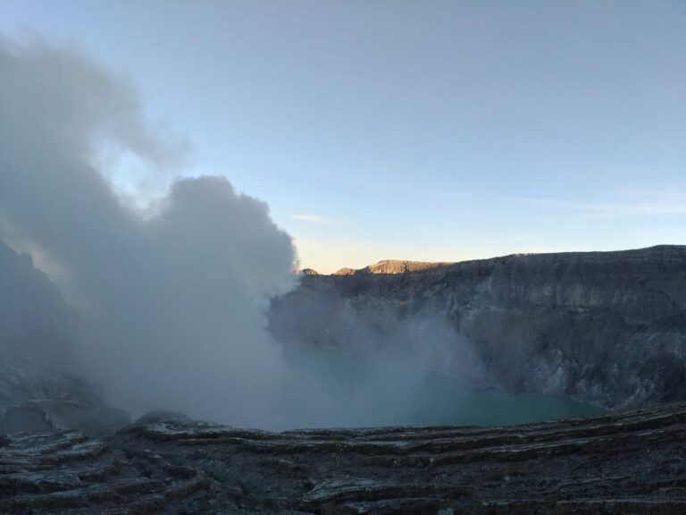 Sulfur smoke drifting over the Ijen crater lake at dawn