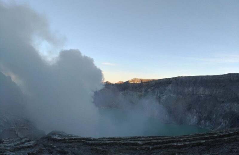 Sulfur smoke drifting over the Ijen crater lake at dawn