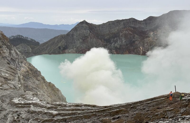 Turquoise crater lake of Kawah Ijen with sulfur smoke